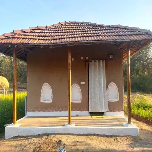 खपरैल की छत और मिट्टी के रंग वाली दीवारों का एक होमस्टे।